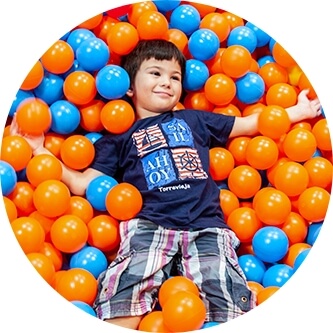 A boy swims in a pool with balloons